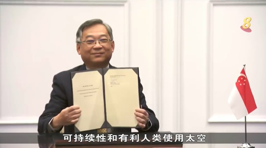 Image of Singapore’s trade and industry minister Gan Kim Yong holds up the Artemis Accords signed between Singapore and the United States in Washington, March 28, 2022.
