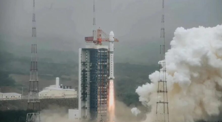Orange exhaust blasts the ground as a 41-meter-tall, white Long March 2D rocket begins to rise above its fog-shrouded launch tower at the hilly Taiyuan Satellite Launch Center in north China.