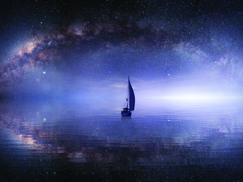A lone sailboat in a sea of stars