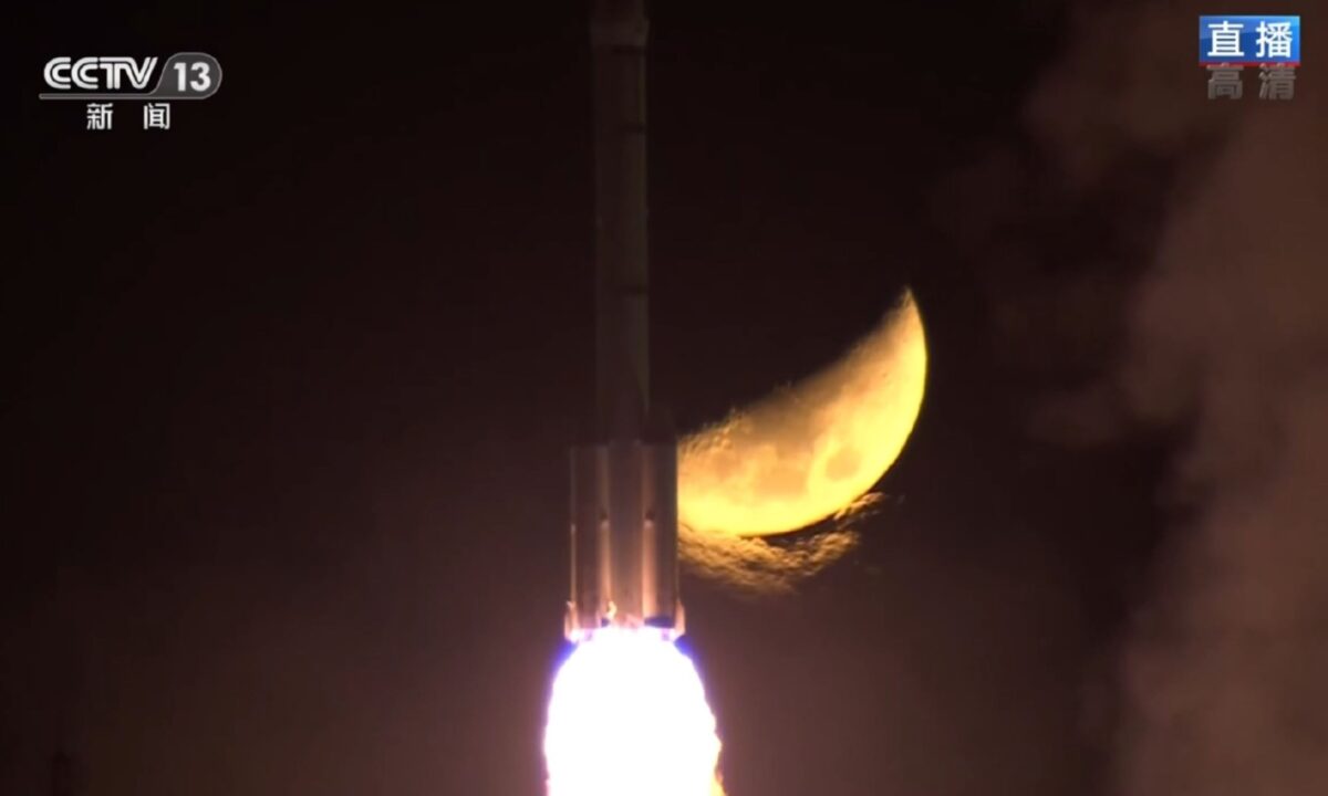 A Long March 2F rocket carrying the Shenzhou-15 spacecraft and crew rises into the sky against a lunar backdrop.