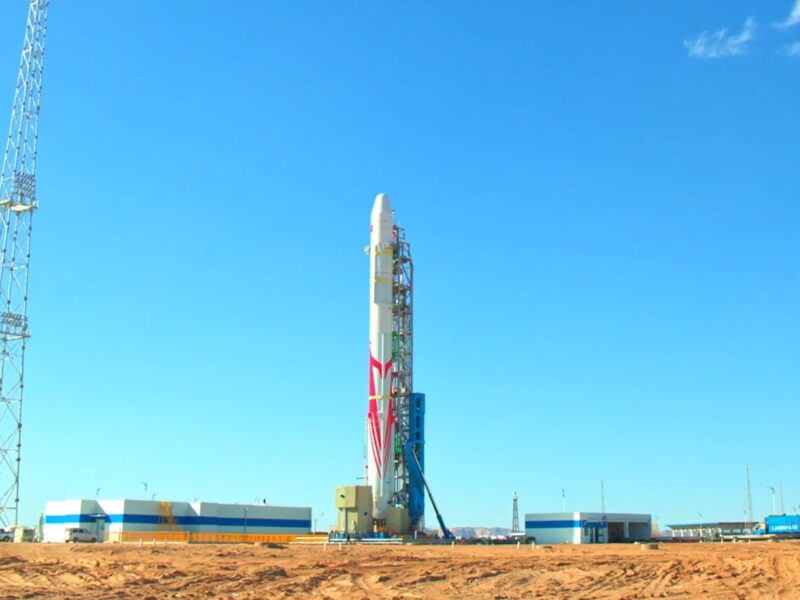 A red and white Zhuque-2 rocket erected at the desert Jiuquan spaceport during testing.