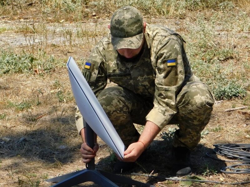 Ukrainian soldier setting up Starlink terminal