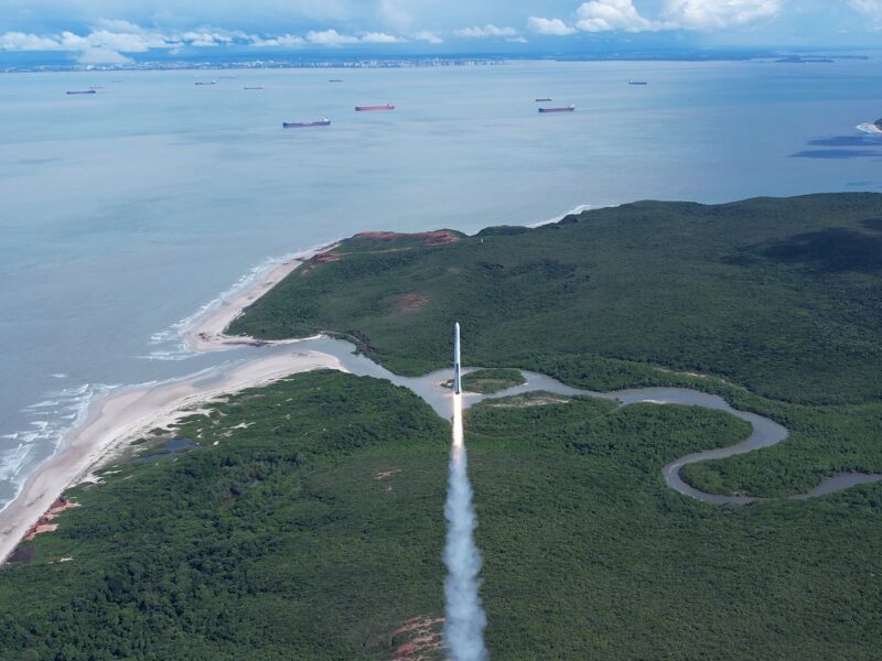 A white rocket lifts off from a seaside launch site in Brazil.